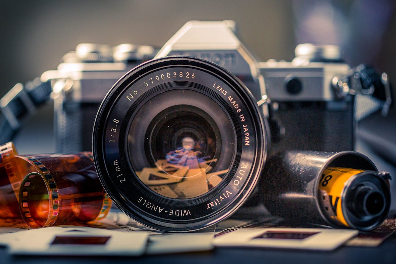 Close-up of a vintage film camera with film negatives and slide frames, capturing nostalgia.